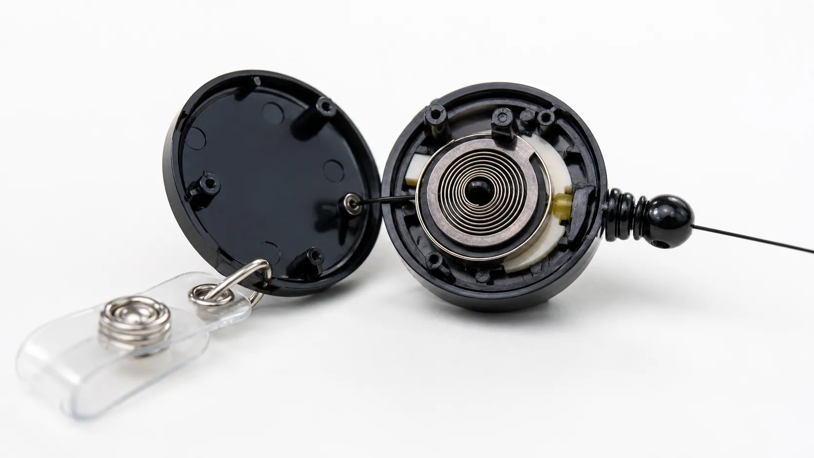 Miniature power spring inside a badge reel and access card retractor